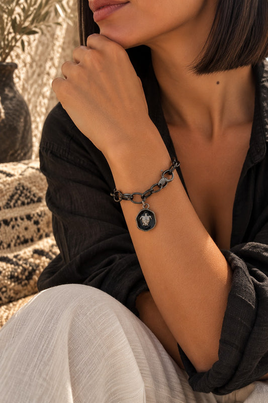 Bracelet SFAX noir avec médaille tortue porté au poignet